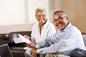 Photo of couple reviewing paperwork. Link to Gifts of Real Estate.